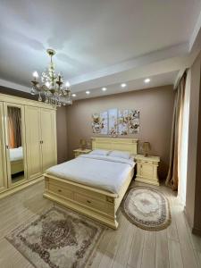 - une chambre avec un grand lit et un lustre dans l'établissement White bridge apartment, à Koutaïssi