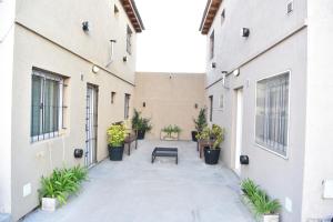 un patio con plantas y un banco en un edificio en Departamentos x dia Viedma 3 CON COCHERA en Viedma