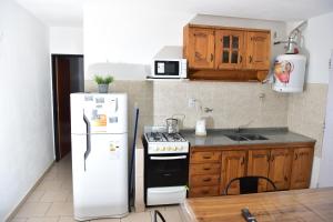 eine Küche mit einem weißen Kühlschrank und einem Herd in der Unterkunft Departamentos x dia Viedma 3 CON COCHERA in Viedma