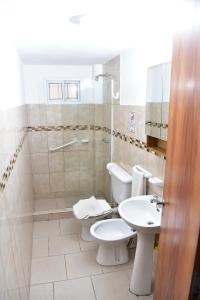 ein Badezimmer mit 2 WCs, einer Dusche und einem Waschbecken in der Unterkunft Departamentos x dia Viedma 3 CON COCHERA in Viedma