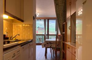 a kitchen with a view of a balcony at Le Margériaz 32m Balcon vue in Aillon-le-Jeune