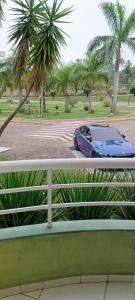 um carro estacionado num parque de estacionamento com palmeiras em Aldeia das Águas Village Flat Térreo em Barra do Piraí