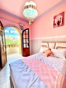 um quarto com uma cama e um lustre em House in Essaouira em Essaouira