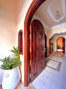 uma grande porta de madeira num quarto com uma planta em House in Essaouira em Essaouira