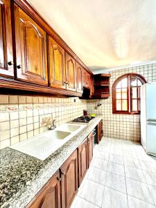 uma cozinha com armários de madeira, um lavatório e um frigorífico em House in Essaouira em Essaouira