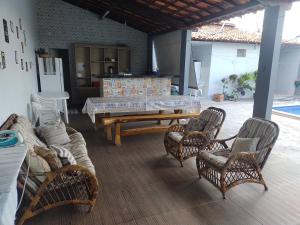 a living room with a table and rattan chairs at Ótimo lugar e conforto in Piranhas