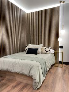 a bedroom with a large bed with a striped wall at Plaza Mayor de Salamanca By LixLoft in Salamanca
