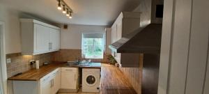 uma cozinha com armários brancos e uma máquina de lavar e secar roupa em Southampton Escape 3BR Home with Garden em Southampton