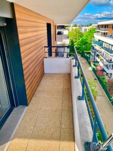 un balcon d'un immeuble avec un mur en bois dans l'établissement Appartement spacieux, à Drancy