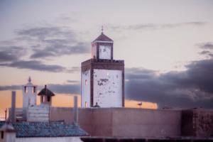 un bâtiment avec une tour d'horloge en haut dans l'établissement Giraffe Hostel-Sea view Rooftop, à Essaouira