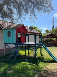 un parque infantil con tobogán y una casa en Cabañas Villa Los Platanos, en La Serena