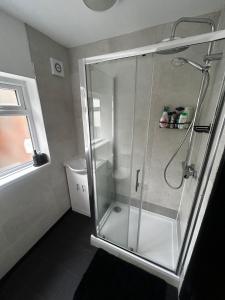 a shower with a glass door in a bathroom at Kensington Stories - 4 Bed House in Watford