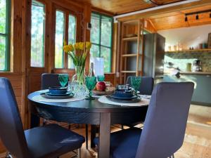 ein Esszimmer mit einem Tisch mit blauen Gerichten und Blumen in der Unterkunft Leśny Zakątek in Krajęczyn