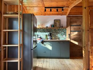 cocina con nevera de acero inoxidable y paredes de madera en Leśny Zakątek, en Krajęczyn