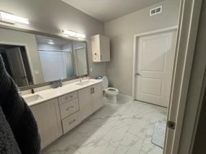 bagno con lavandino, servizi igienici e specchio di InMotion a San Diego