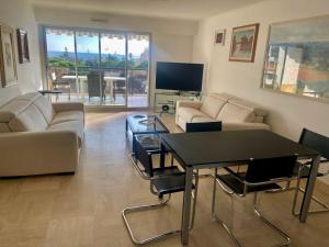 a living room with a table and a couch at Front sea Luxury in Cagnes-sur-Mer
