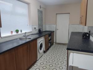 cocina con fregadero y lavadora en 3 Bedroom Entire House en Middlesbrough