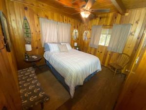 um quarto com uma cama e uma ventoinha de tecto em Knotty Pines Lodge em Bass Lake Annex