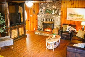 uma sala de estar com um sofá e uma lareira em Knotty Pines Lodge em Bass Lake Annex