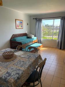 a room with two tables and a bed and a window at Cabañas Villa Los Platanos in La Serena