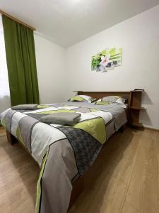 Schlafzimmer mit einem großen Bett und grünen Vorhängen in der Unterkunft Casa Decebal in Călimăneşti