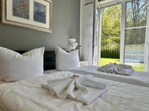 2 letti bianchi con asciugamani in una camera da letto di Haus Sonne a Thiessow