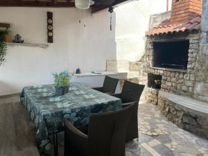 a patio with a table and chairs and a fireplace at Libra in Okrug Gornji