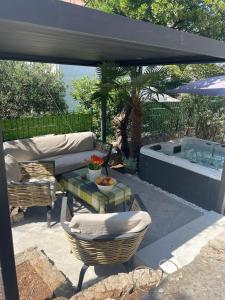 Un patio con jacuzzi y una mesa y sillas. en Libra, en Okrug Gornji