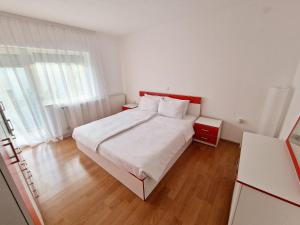 a bedroom with a white bed with a red headboard at Serenity Apartment in Bitola