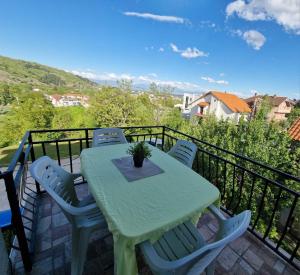 un tavolo verde e sedie sul balcone di Serenity Apartment a Bitola