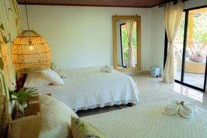 a bedroom with two white beds and a lamp at Ecohotel Yachay Tayrona in El Zaino