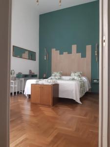 1 dormitorio con 1 cama con sábanas blancas y suelo de madera en Intrecci & Impasti en Nápoles