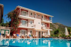 a hotel with a swimming pool in front of a building at G George in Nydri