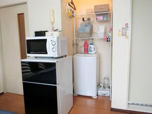 a kitchen with a microwave and a small refrigerator at Grandeur Imagawa - Vacation STAY 11149 in Urayasu