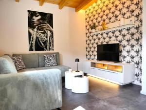 sala de estar con sofá y TV en Villa Kolberg, en Finkenstein