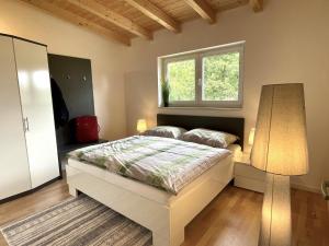 1 dormitorio con 1 cama con lámpara y ventana en Villa Kolberg, en Finkenstein
