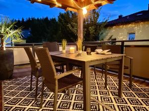 una mesa de madera y sillas en un patio en Villa Kolberg, en Finkenstein