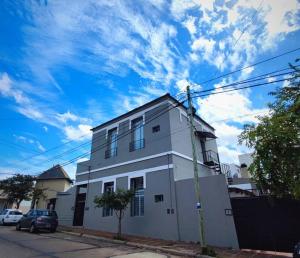 une maison blanche avec une voiture garée devant elle dans l'établissement Departamentos Espejo Dpto A, à Concordia