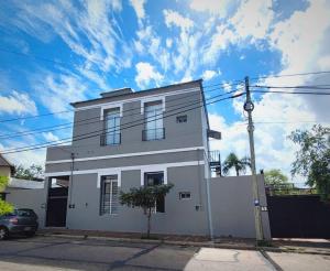 une maison blanche avec une voiture garée devant elle dans l'établissement Departamentos Espejo Dpto A, à Concordia