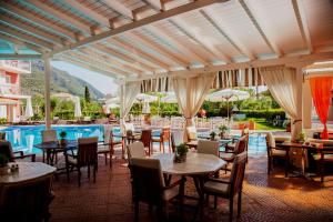 a restaurant with tables and chairs and a pool at G George in Nydri