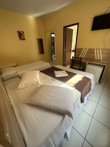 um quarto de hotel com duas camas e uma televisão em Recife Palace Hotel em Parauapebas