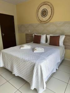 um quarto com uma cama grande e lençóis brancos em Recife Palace Hotel em Parauapebas