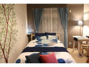 1 dormitorio con 1 cama de color azul y blanco en Maison Cresta Urayasu - Vacation STAY 11150, en Urayasu