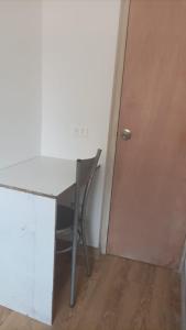 einen Schreibtisch mit einem Stuhl neben einer Tür in der Unterkunft Habitacion 401,402,403,404 in Medellín