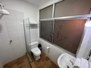 a bathroom with a shower and a toilet and a sink at Perla Suites Malecón in Guayaquil