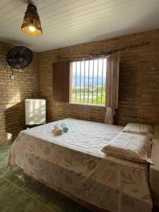 貝貝里比的住宿－Pousada sol nascente，窗户客房内的一张大床
