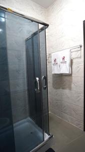 a shower with a glass door in a bathroom at SHORTLETMART Apartments in Lekki