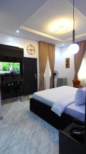 sypialnia z łóżkiem, biurkiem i telewizorem w obiekcie SHORTLETMART Apartments w mieście Lekki