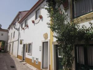 a white building with a door on a street at Casinha da Pedra in Tomar