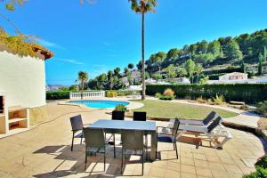 モライラにあるAlldo - hill side with private pool in Morairaのパティオ(テーブル、椅子付)、プールが備わります。